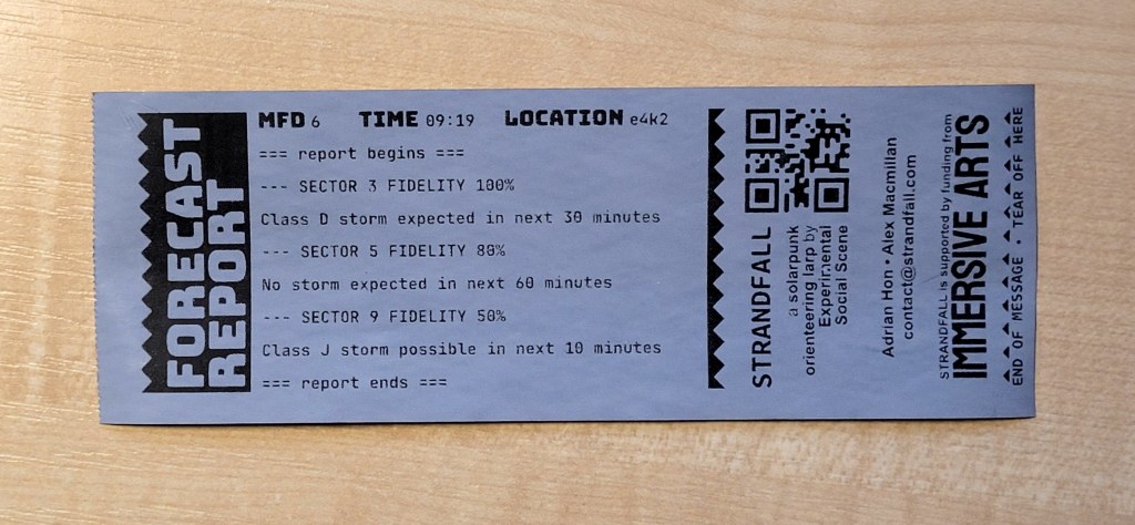 A photograph of a printed receipt showing a fictional "Forecast Report", and then information about Strandfall, a QR code and the Immersive Arts logo