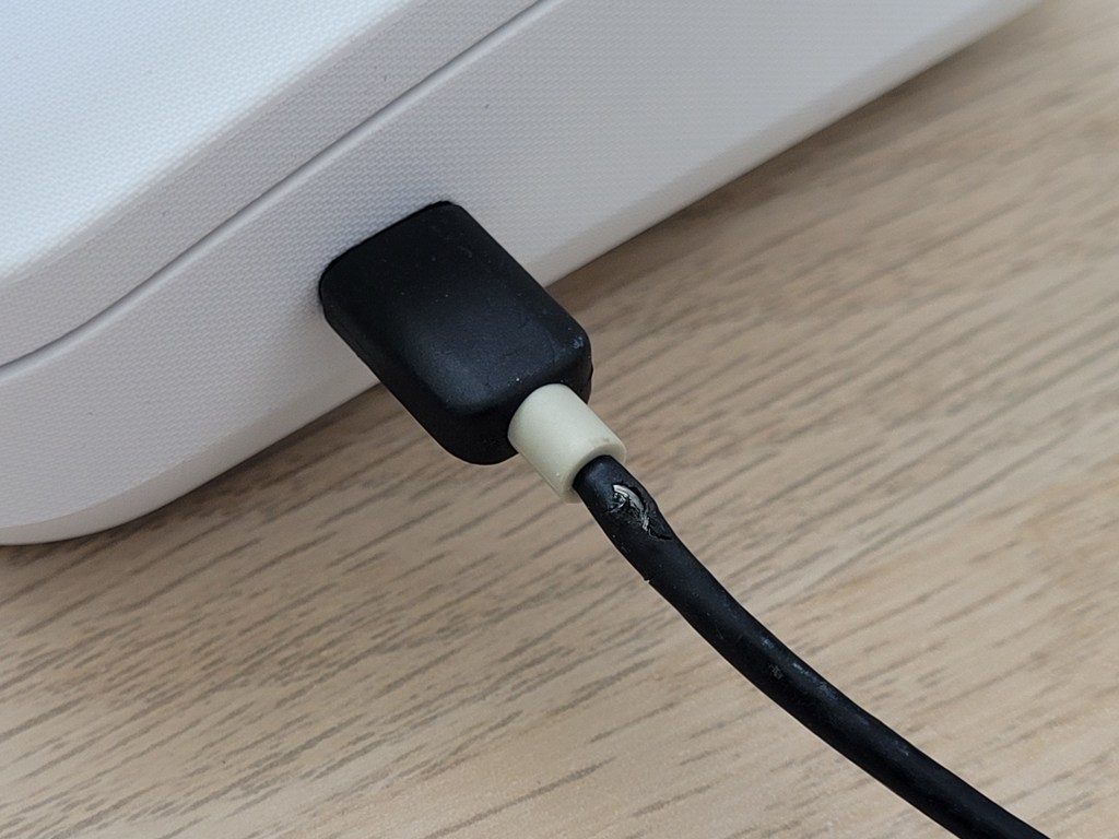 A close-up of a USB cable connected to the receipt printer. The cable sheath has suspicious signs of damage, wire is visible through damage in the plastic sheath.